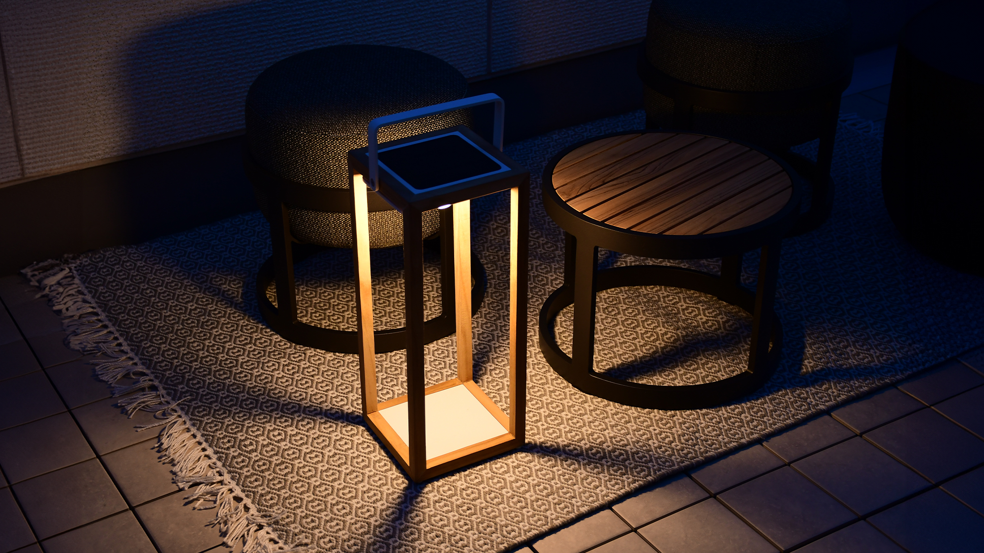じゅうたんを敷いたベランダにテーブルセットを置いて、リヒトルクスフロアチークを灯している空間